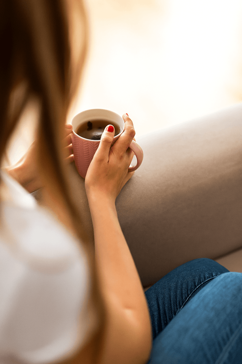 Een warme, persoonlijke sfeer met een vrouw die geniet van een rustig moment met koffie